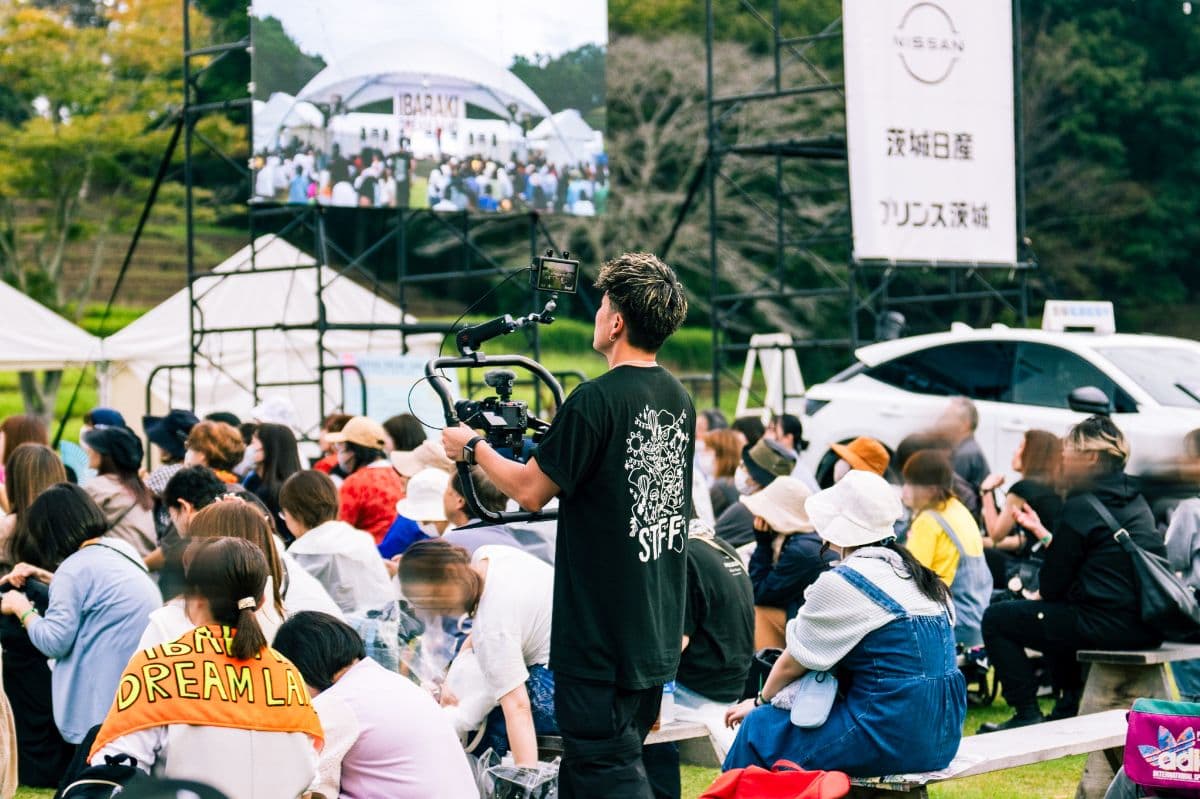 野外イベントでジンバルカメラを構えて撮影する様子